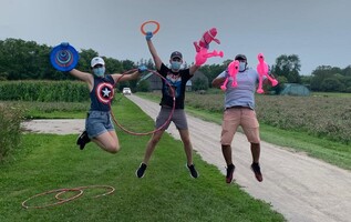 Summer Camp Staff jumping up while holding camp props